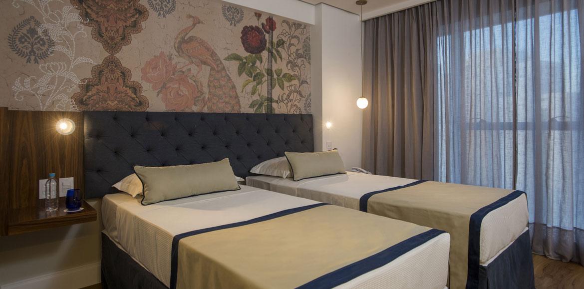 Hotel Luzeiros Recife Bagian luar foto The photo shows a modern bedroom featuring two single beds that are neatly made with light-colored blankets and decorative pillows. The headboard of the beds is upholstered in a dark material, giving it a stylish appearance. Behind the beds, there is